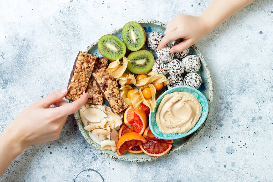 Imagem de um prato contendo frutas, barrinhas de cereal e outros alimentos saudáveis